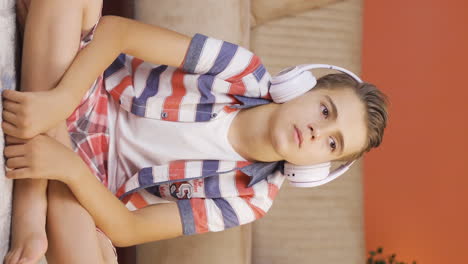 Vertikales-Video-Eines-Jungen,-Der-Zu-Hause-Mit-Kopfhörern-Musik-Hört